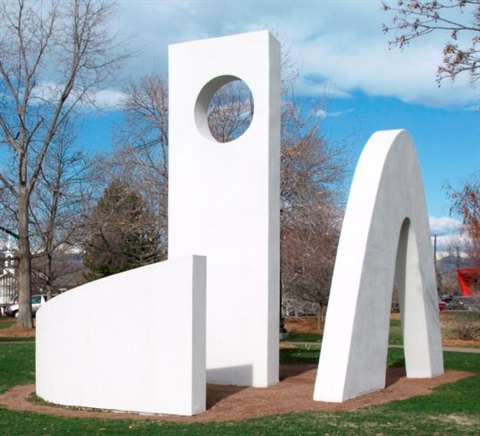 Three large white abstract sculptures in a park