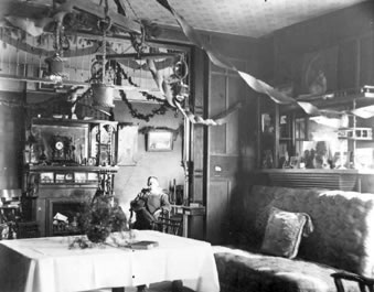 Samuel T. Culp in the sitting room of the Culp house, 5554 S. Prince St., c.1906. This photo shows small dining and living room adjacent to the sitting room.