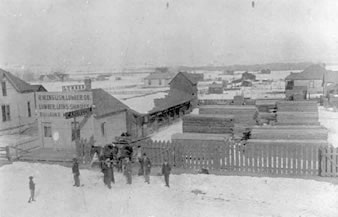 Littleton Lumber Co. on the north side of the 2400 block of Main Street, c.1890. The house on the far left is sitting on the property now covered by the Coors Building at the corner of Main Street and Nevada. Men in the photo include R.W. English and Harry Nutting.